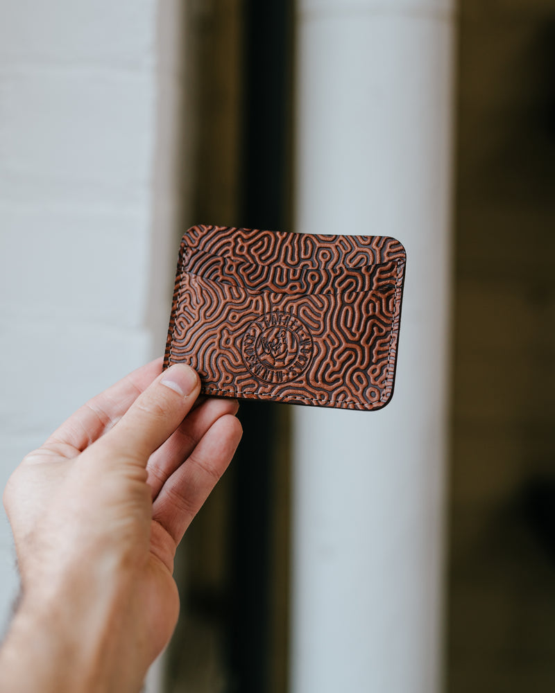 Leather Works MN No. 5 Wallet in Coral Saddle Tan held up in a hand